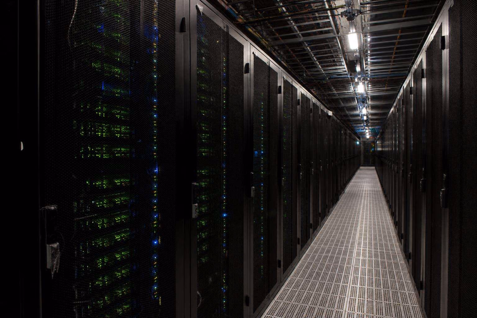 Cold aisle between rows of server cabinets in a data hall