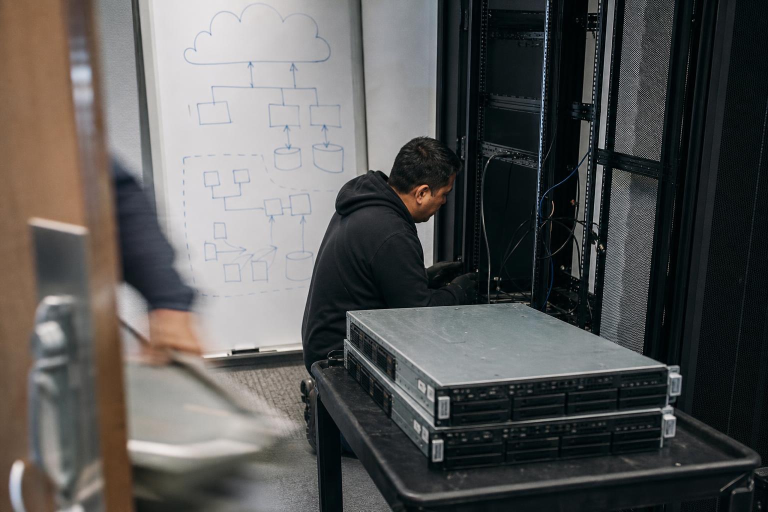 Engineer removing servers from a rack beside a migration diagram, in Glendale